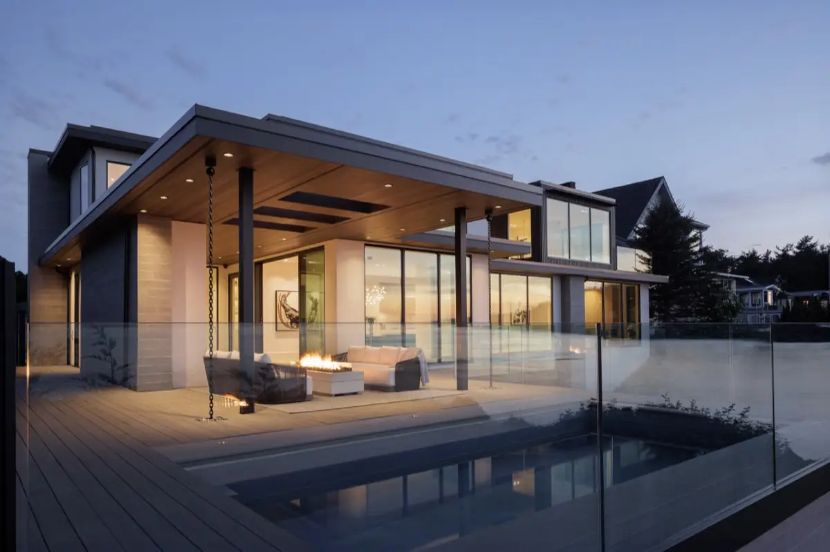 Covered terrace, fire table and pool at dusk