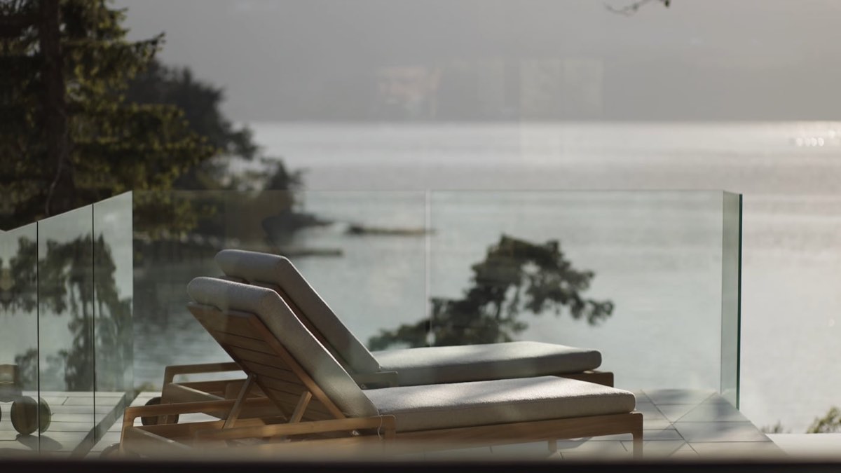 Lounger on a glass-railed deck over the sea
