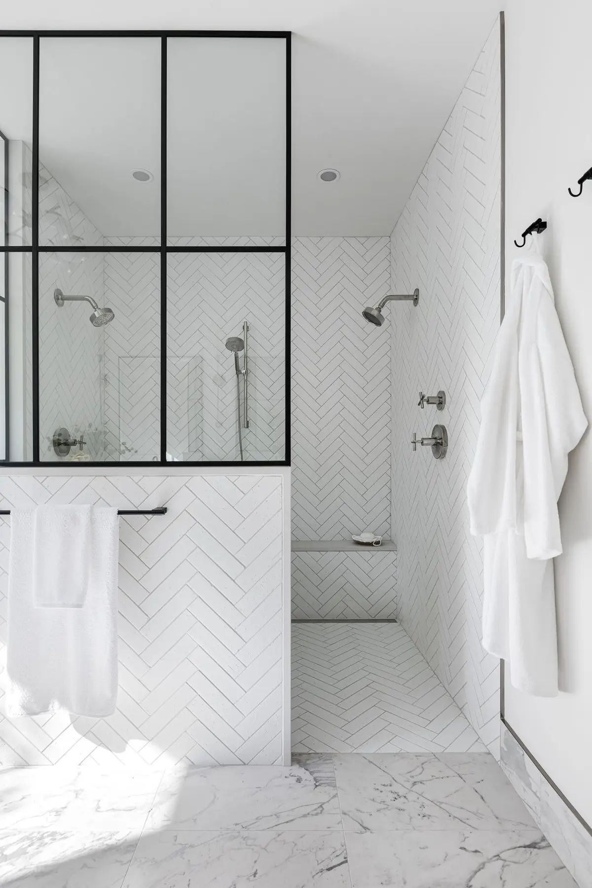 Glass-walled shower in a white bathroom