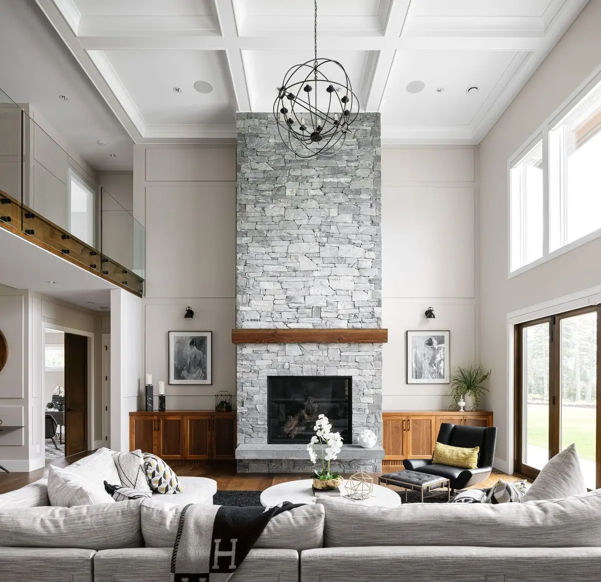 Double-height living room with a stone fireplace