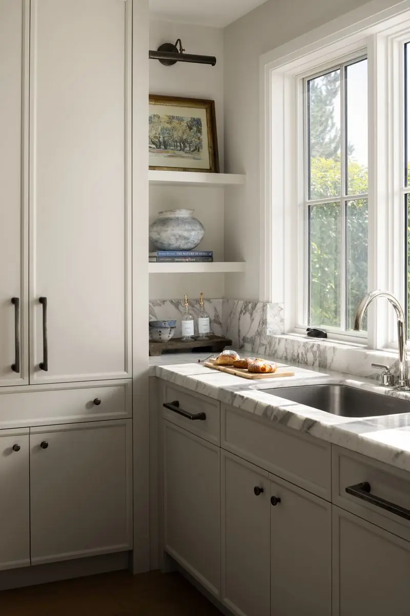 Sink beneath a window and open shelves