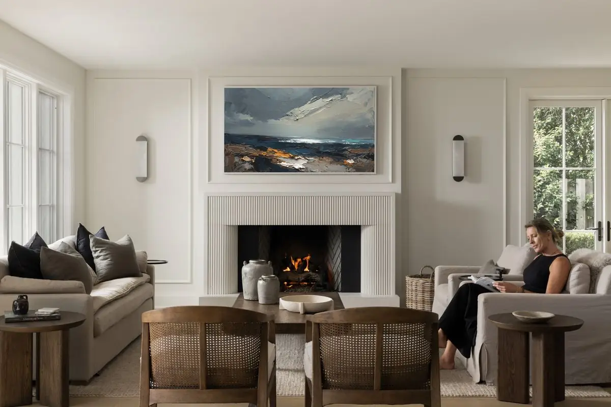 Reading by the fire, a seascape above the mantel