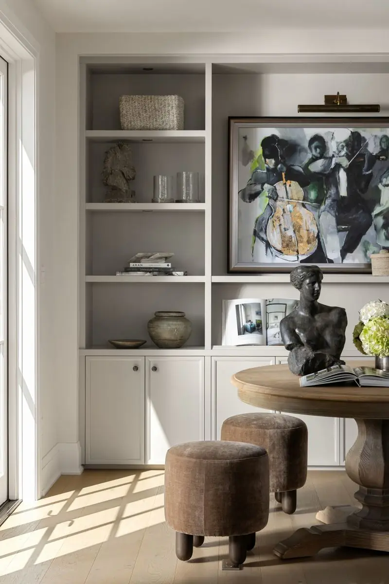 Built-in shelves, a sculpture and a painting above a round table