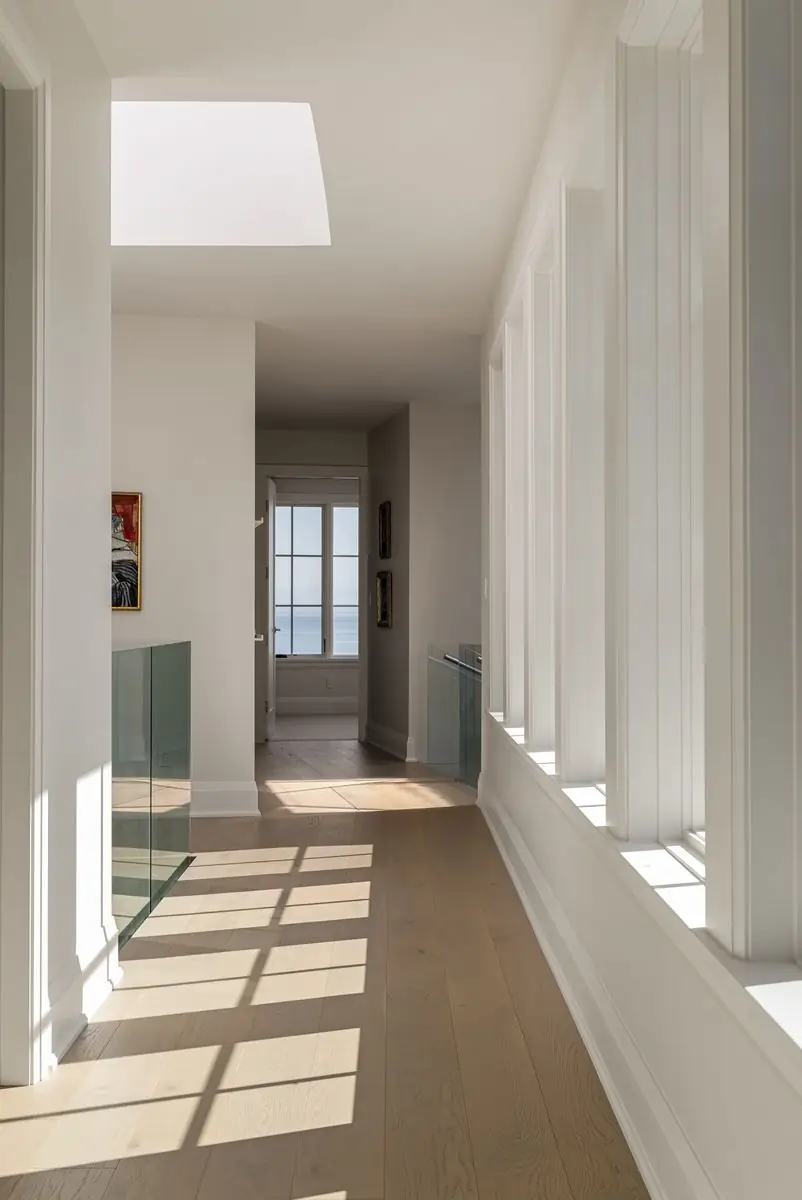 Sunlit hallway lined with tall windows
