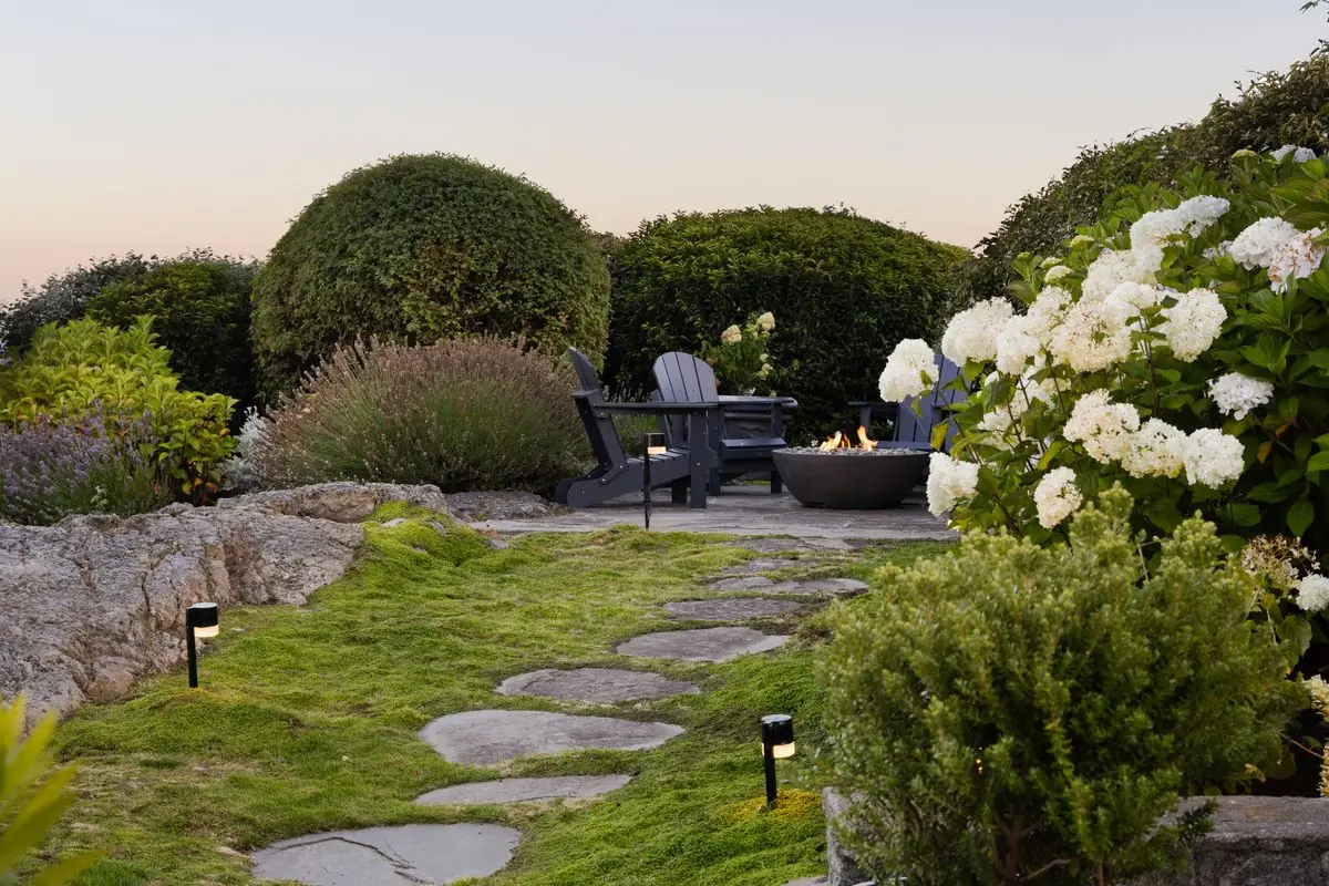 Garden with stepping stones, hydrangeas and a fire bowl