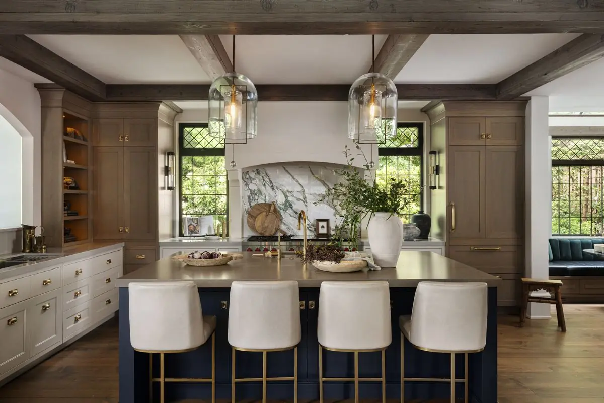 Kitchen island with four white stools under timber beams