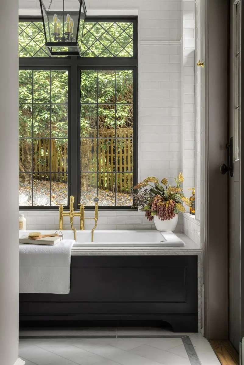 Tub with brass taps by a leaded window