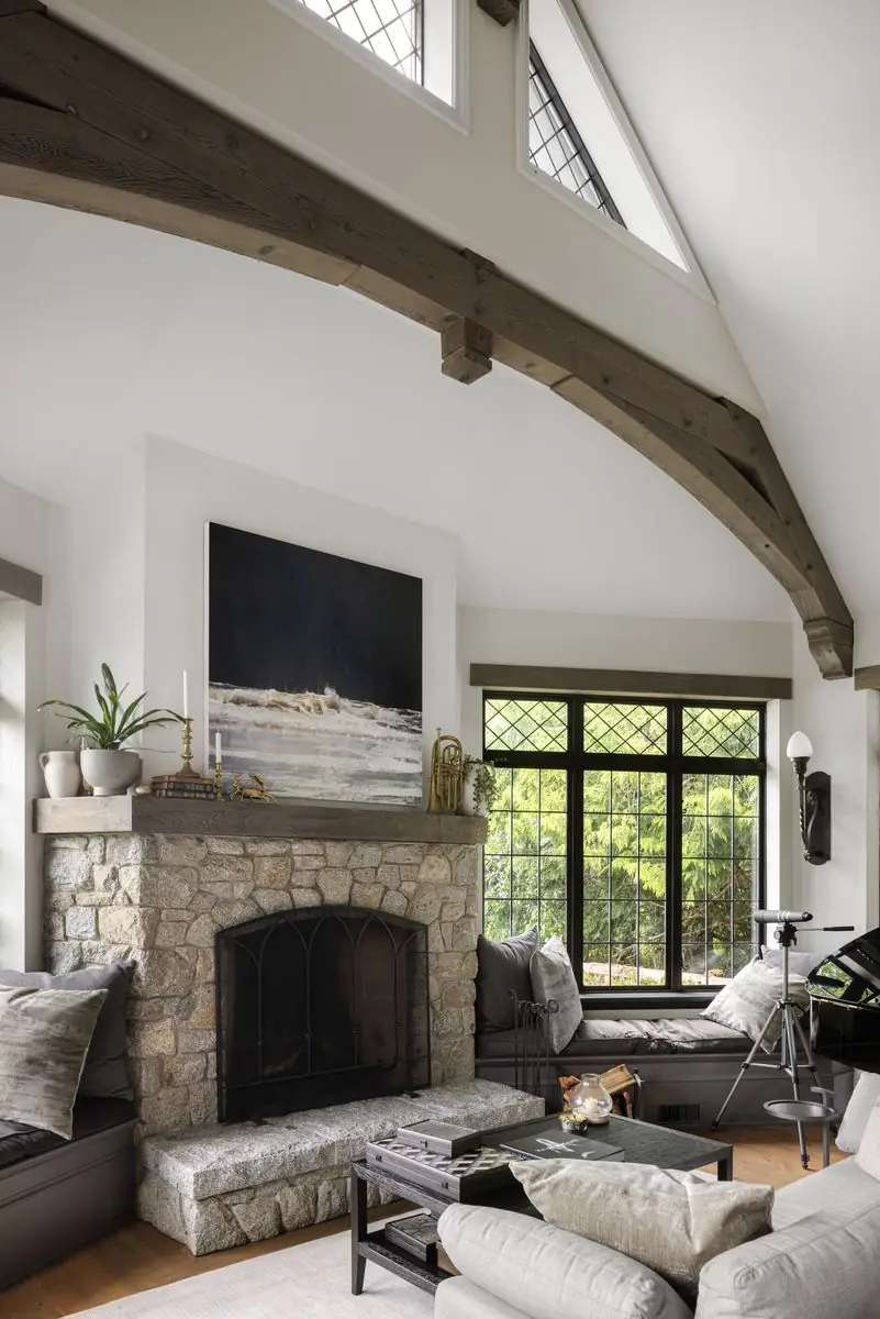 Sitting room with a stone fireplace under timber trusses