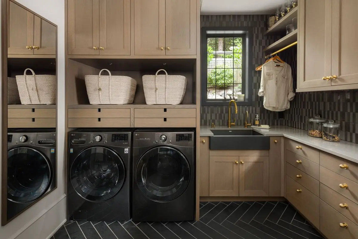 Laundry room with oak cabinets and a black herringbone floor