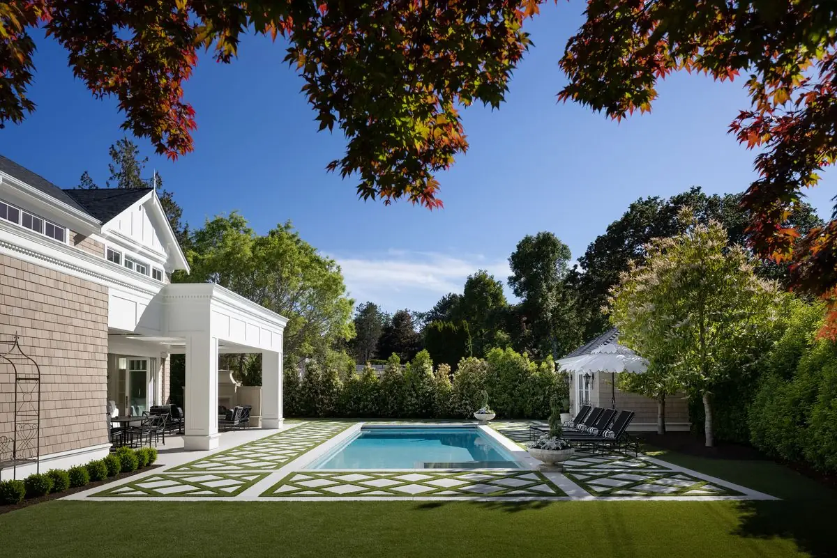 Pool and pool house across the back lawn, under maple leaves