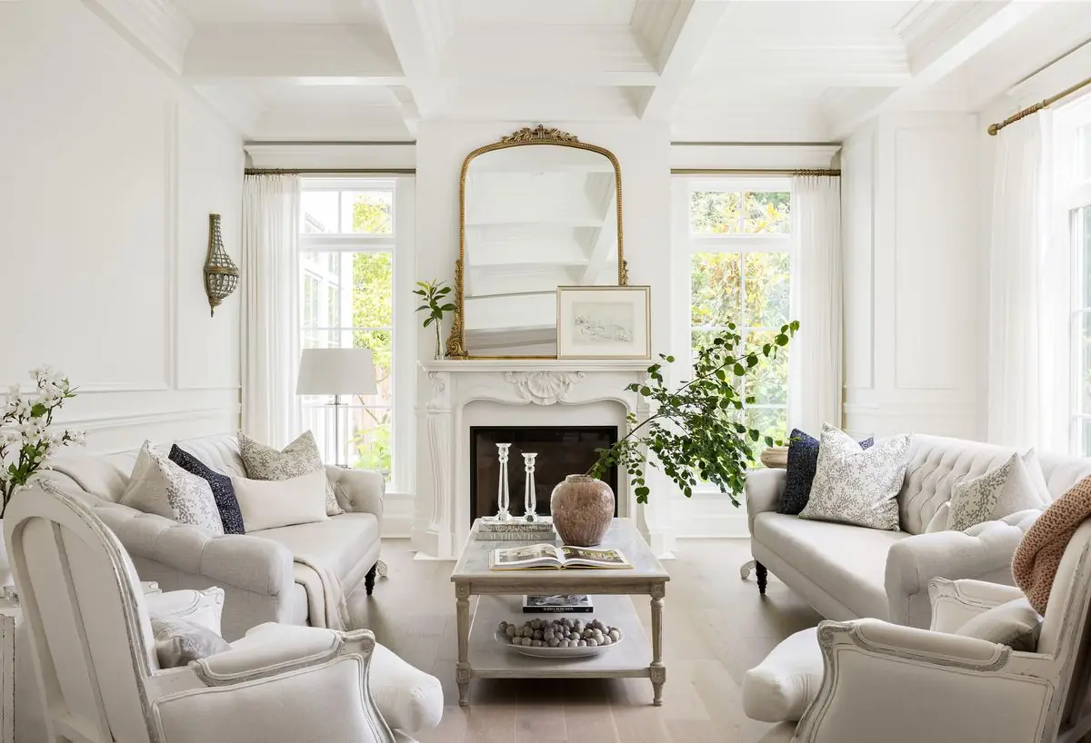 Living room in white, a gilded mirror over the fireplace