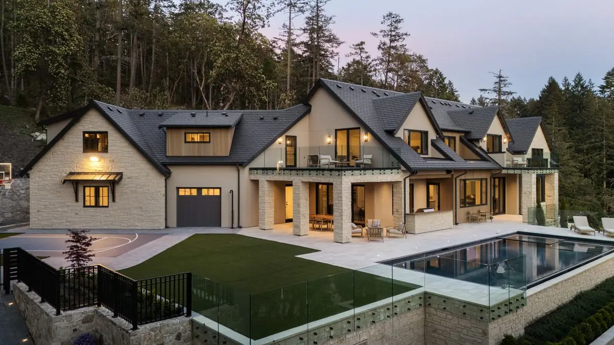 Front of the house, the lawn and the pool at dusk