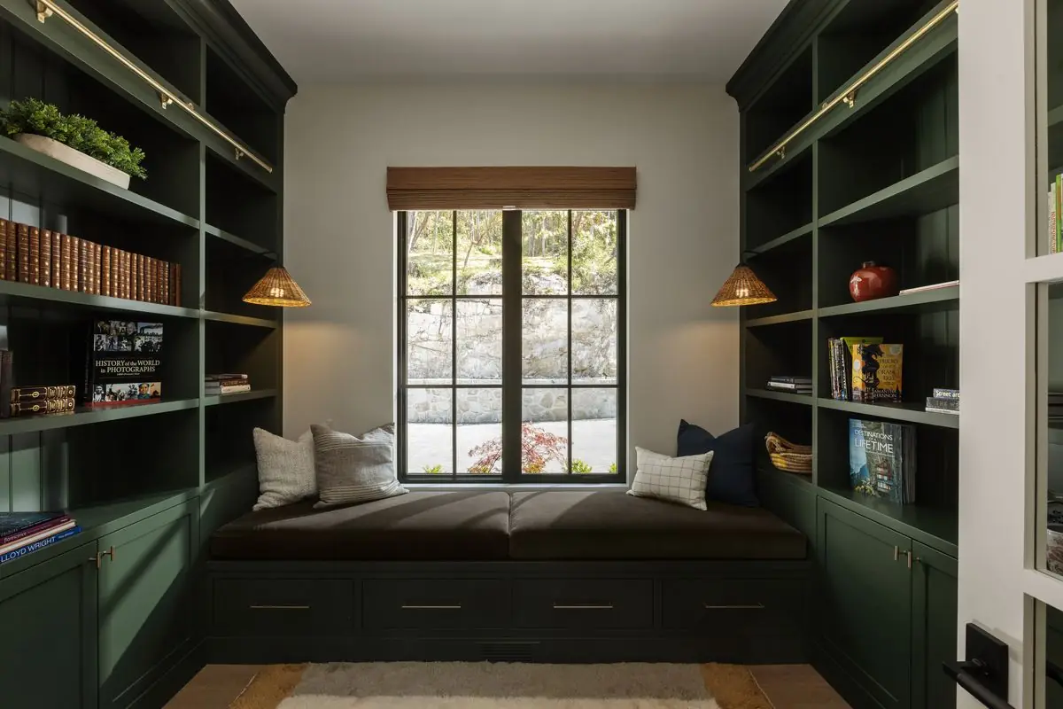 Library window seat in green built-ins