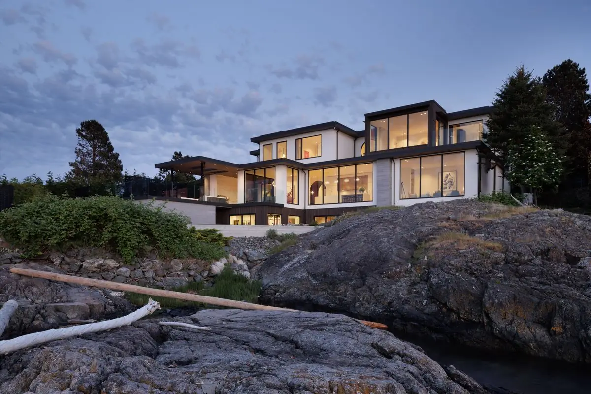The house above the shoreline rocks at dusk