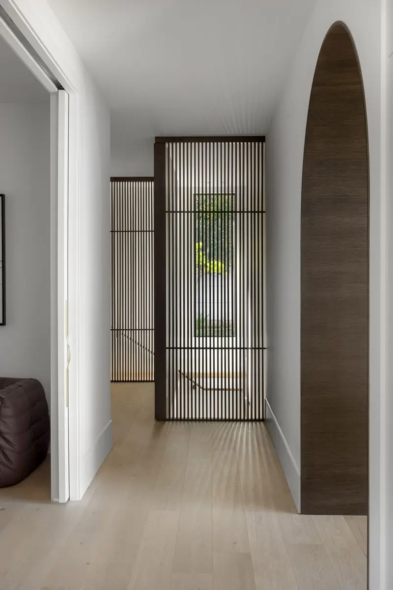 Hallway with a slatted screen and a tall arched door