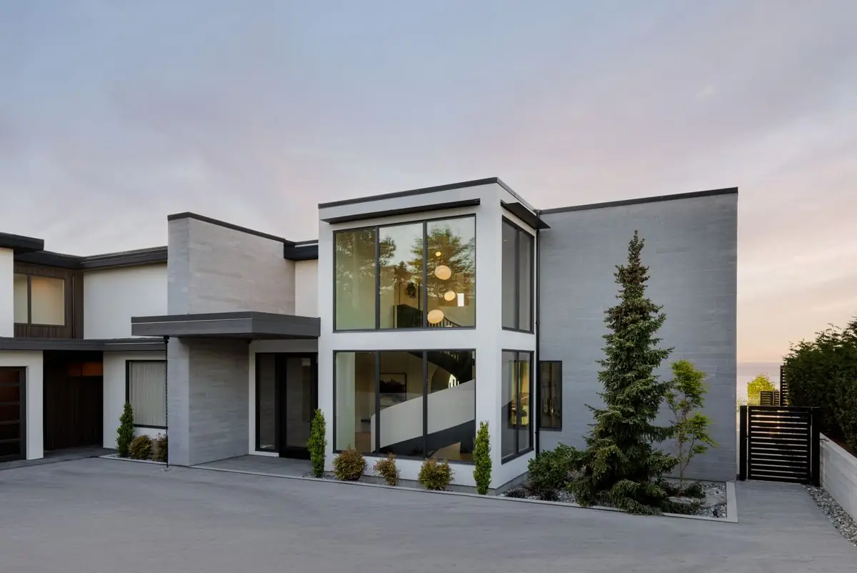 The front of the house at sunset, with a tall evergreen