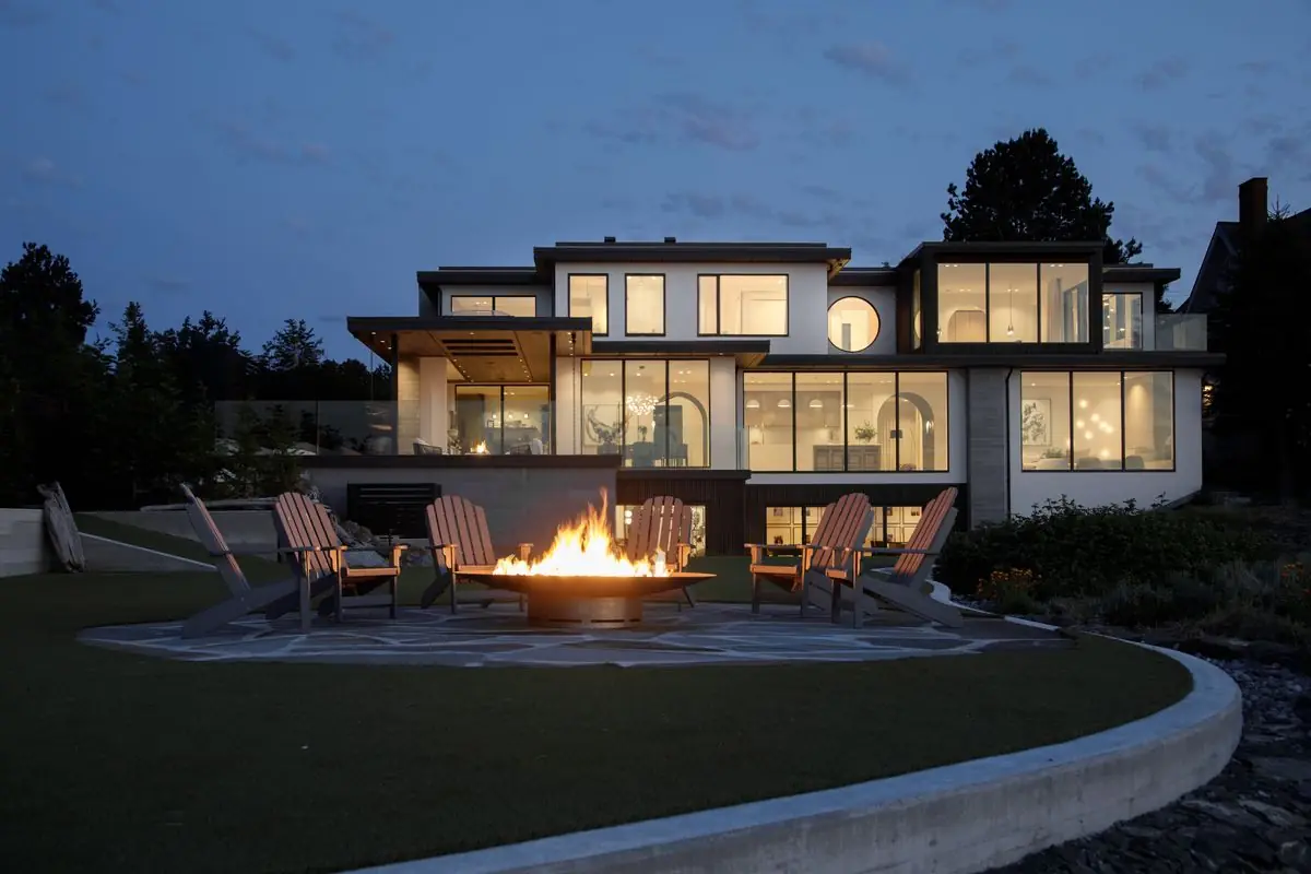Fire pit and chairs on the lawn behind the house at night