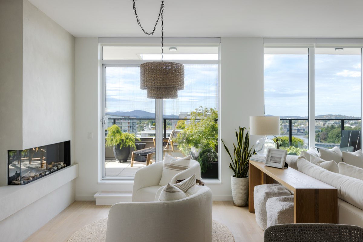 A great room under a drum pendant, white walls and a long view.