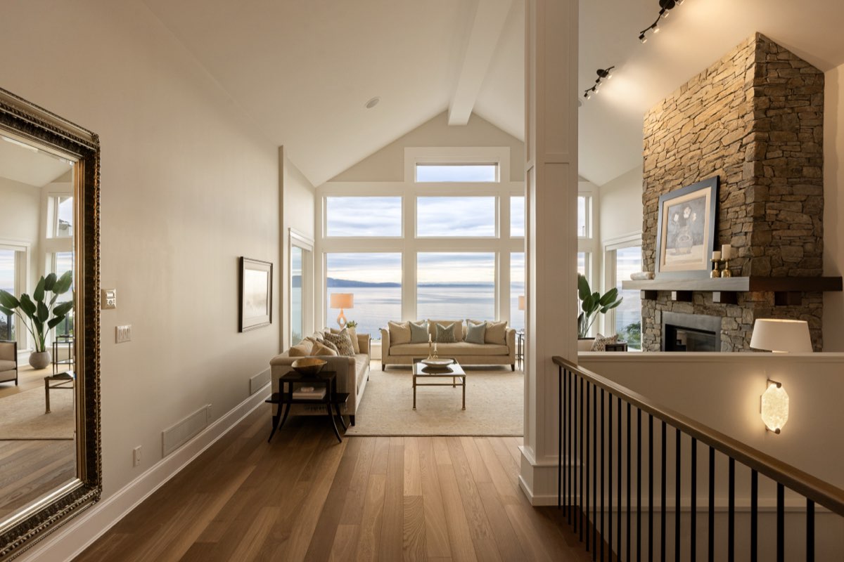 A vaulted living room in oak with a staircase rising to a mezzanine.