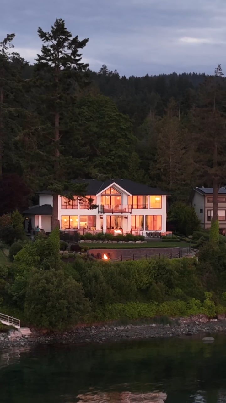 Lochside home lit at dusk across the water